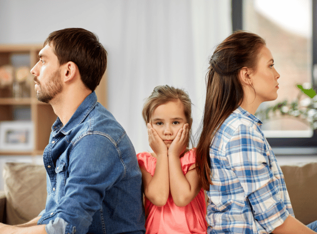 A child sits between her parents, who face away from each other
